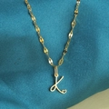 Gouden ketting met letter K hanger en hartje op donkerblauwe zijden stof - Goud-K