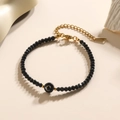 Minimalistische zwarte kralenarmband met een gouden letter C hanger en sluiting - Letter - C