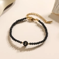 Minimalistische zwarte kralenarmband met een gouden letter J-bedel en verstelbare ketting - Letter - J