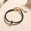 Minimalistische zwarte kralenarmband met gouden letter M bedeltje en ketting - Letter - M