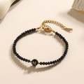 Gefacetteerde zwarte kralenarmband met een gouden letter N bedel en verstelbare sluiting - Letter - N