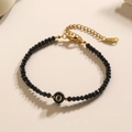 Kralenarmband met zwarte gefacetteerde stenen en gouden hanger met de letter O - Letter - O