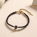 Minimalistische zwarte kralenarmband met gouden letter Q bedel en verstelbare sluiting - Letter - Q