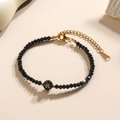 Minimalistische zwarte kralenarmband met gouden letter R bedeltje en verstelbare sluiting - Letter - R