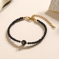 Minimalistische kralenarmband met zwarte kralen en een gouden letter S bedeltje - Letter - S