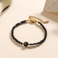 Elegante kristallen kralenarmband met zwarte kralen en gouden letter V bedeltje - Letter - V