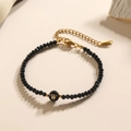 Zwarte kralen armband met gouden letter W bedeltje en verstelbare roestvrijstalen ketting - Letter - W