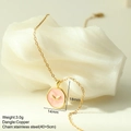 Detail of pink enamel round pendant with golden wings on stainless steel chain - Pink Wing Style (MFNK024G11)