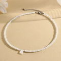 White faceted beaded necklace featuring a shell capital letter E pendant and lobster clasp - E (SHNK2434)