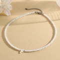 White beaded necklace featuring a shell-style letter F pendant and adjustable silver clasp - F (SHNK2434)