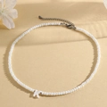 Faceted white bead necklace with shell-textured letter K pendant and silver clasp - K (SHNK2434)