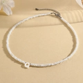 White beaded necklace featuring a letter Q pendant with faceted beads and silver clasp - Q (SHNK2434)