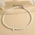 White beaded necklace featuring a faceted V letter pendant with lobster clasp closure - V (SHNK2434)