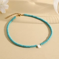 Beaded turquoise necklace with a white letter E pendant and golden metal clasp - E (SHNK2435)