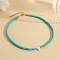 Light blue turquoise beaded necklace featuring a white shell letter T pendant charm - T (SHNK2435)