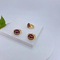 Detail van drie vergulde smiley-ringen met rozerode steeninleg op een marmeren voet - Rozerood Pave Lachend Gezicht Stijl (#3)