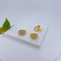 Macro-opname van gouden smiley ringen met zirkonia pavé op een witte stenen basis - Witte Volledige Strass Lachende Stijl (#4)