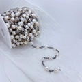 Detailed view of Baroque pearl chain with zircon accents on a reel for jewelry making - White Pearl-Gunmetal Chain