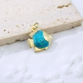 Macro detail of a fish-shaped pendant with gold edges and vibrant turquoise enamel - Blue 2