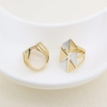 Detail of two-tone geometric rings featuring gold and silver plating on a ceramic tray - Geometric Triangle Style (#2)