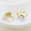 Macro detail of two-tone 18K plated irregular teardrop rings in a ceramic dish - Organic Teardrop Design (#10)