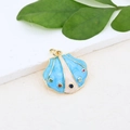 Detailed macro view of sea shell charm in gold plating with colorful zircon stones - Blue Beige Scallop Pendant (#2)