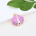 Macro shot of seashell pendant with purple enamel and colorful stones on a stone surface - Purple White Scallop Pendant (#3)