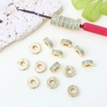 Vista macro di distanziatori dorati 14k con zirconi turchesi per creazione gioielli - 8mm / Oro / Zirconia Ciano