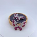 Macro-detail van vlinderbroches met pavé-gezette zirkoon en magenta stenen op hout - Rode Strass