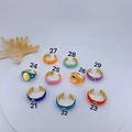 Macro shot of colorful enamel evil eye rings in vibrant summer colors on display - Orange Disc Evil Eye Ring (21)