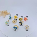 Detailed top view of nine colorful enamel rings with star and heart designs on white tray - Star Enamel Open Ring (78)