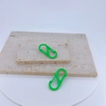 Dettaglio di moschettoni a S verde brillante con clip a molla su sfondo in pietra - Verde Frutta