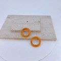 Macro detail of vibrant orange spring ring clasps on elegant stone texture background - Bright Orange