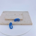 Macro detail of blue macaron spring carabiner hooks on stone display stand - Bright Blue