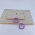 Close-up of two light purple round metal spring ring clasps on a beige stone surface - Light Purple
