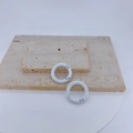 Macro view of two white round spring gate rings on stone for DIY jewelry and keychain - White