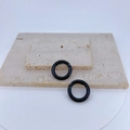 Close-up of two black matte spring O-rings on a textured stone display for DIY jewelry - Black