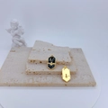 Detailed macro view of gold bee and moon enamel charms on an elegant stone tray - Black