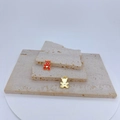 Detailed view of red enamel bear pendants with gold heart on stone display - Red