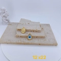 Vista detallada del dije de ojo turco con esmalte azul y acabado chapado en oro texturizado - Estilo de lágrima dorada