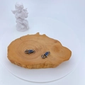Makro-Detail von gunmetal Karabinerverschlüssen mit blauen Zirkonia auf Holzstruktur - Waffenschwarz mit Blauem Zirkon