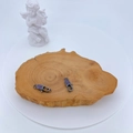 Makroaufnahme von schwarzen Karabinerverschlüssen mit lila Zirkon auf Holzständer - Waffenschwarz mit Violettem Zirkon