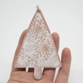 Nahaufnahme von Weihnachtsbaumschmuck aus Holz mit Schneeflockenmuster und Hanfseil - Schneeflocken-Muster