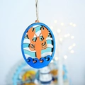 Detail of laser-cut layered wooden lobster ornament with blue ocean waves and rope - Lobster