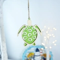 Detail of wooden sea turtle wall hanging with green shell and rustic nautical decor - Turtle