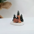 Detail einer Weihnachts-Rentierfigur aus Harz mit grünen Tannen auf Schneebasis - Hirsch
