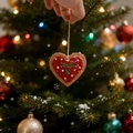 Nahaufnahme eines herzförmigen Christbaumschmucks mit festlichem Schnee und Bokeh-Lichteffekt - Herz