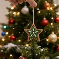 Detail eines sternförmigen, waldgrünen Weihnachtsschmucks mit Punkten in der Hand - Pentagramme
