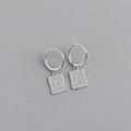 Detalle de pendientes de aro en plata S925 con colgante grabado de la Torre Eiffel - Plata 925 / Oro blanco
