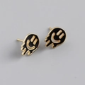 Detail shot of melting smiley face earrings with gold trim and black enamel finish - 925 Silver / Black (Gold)